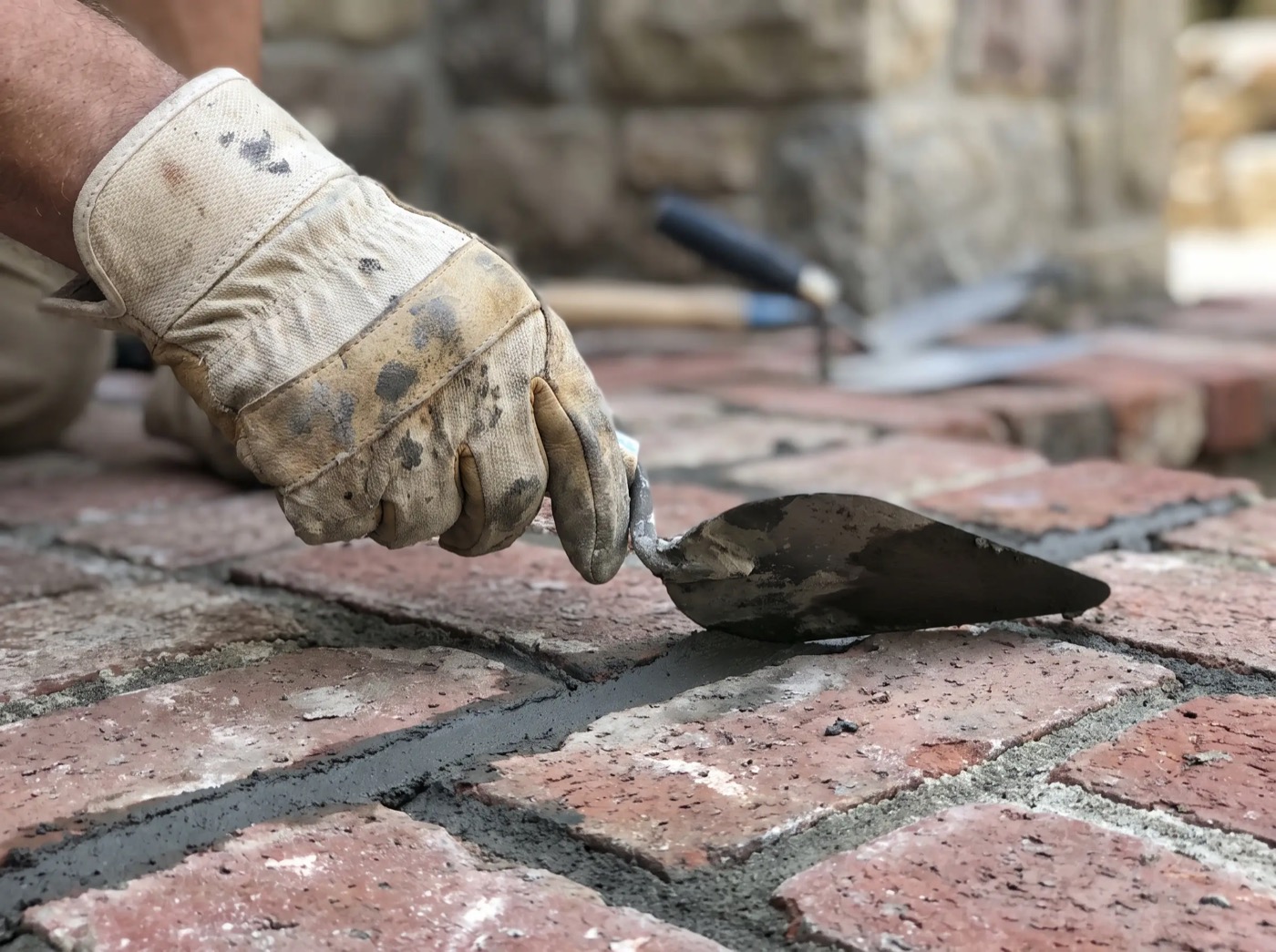 Mason repointing a mortar joint, close up